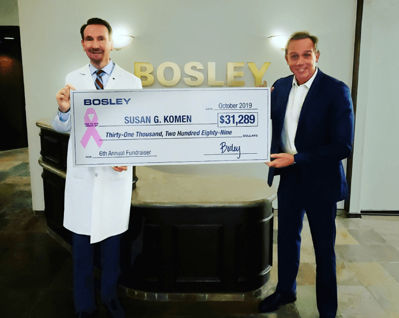 Dr and CEO holding check for Cancer Awareness Donation