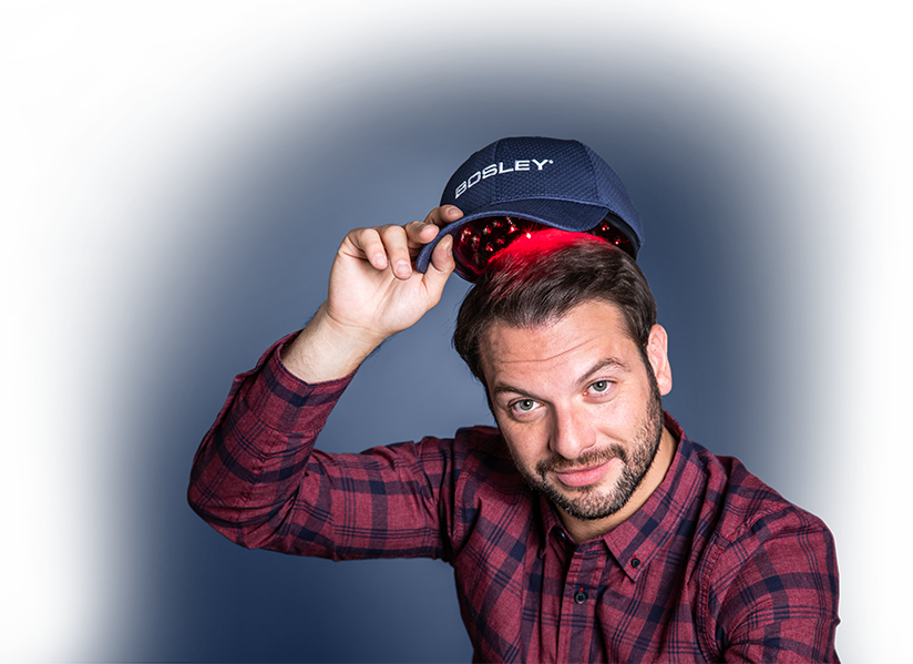 Man putting on a Bosley Low Level Laser Therapy hat